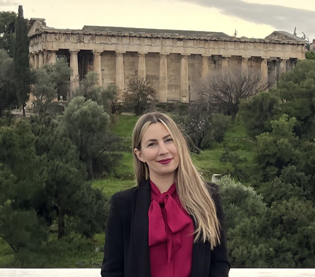 Eleni Moraiti, founder of Untold Journeys, in Athens with the Temple of Hephaestus behind her