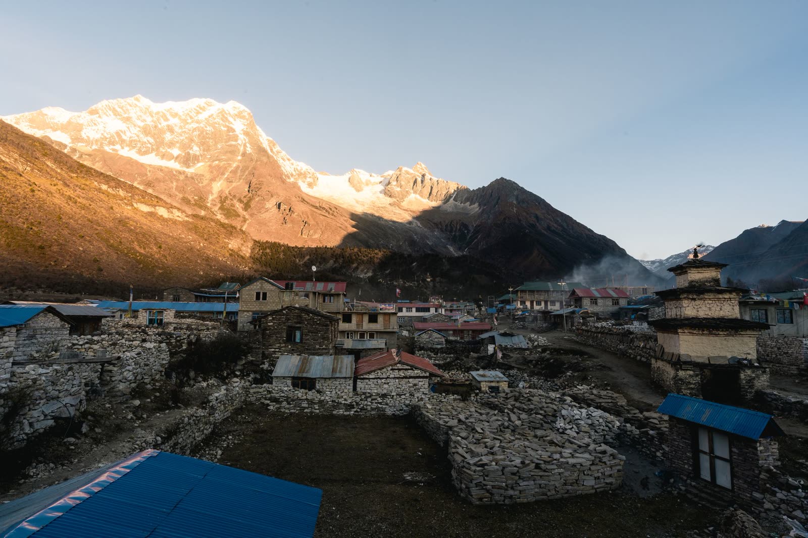 Mountain village beneath snow-capped Himalayan peaks
