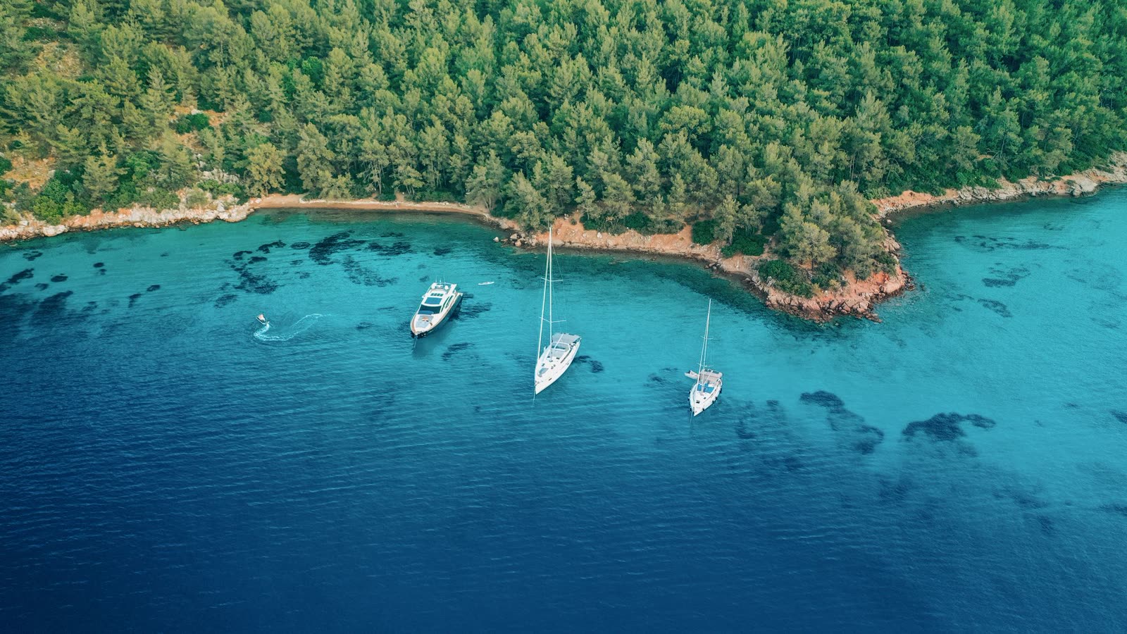 Aerial view of yachts at anchor in a turquoise cove